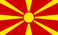 Red flag with a yellow circular sun and radiating rays forming a sunburst pattern.